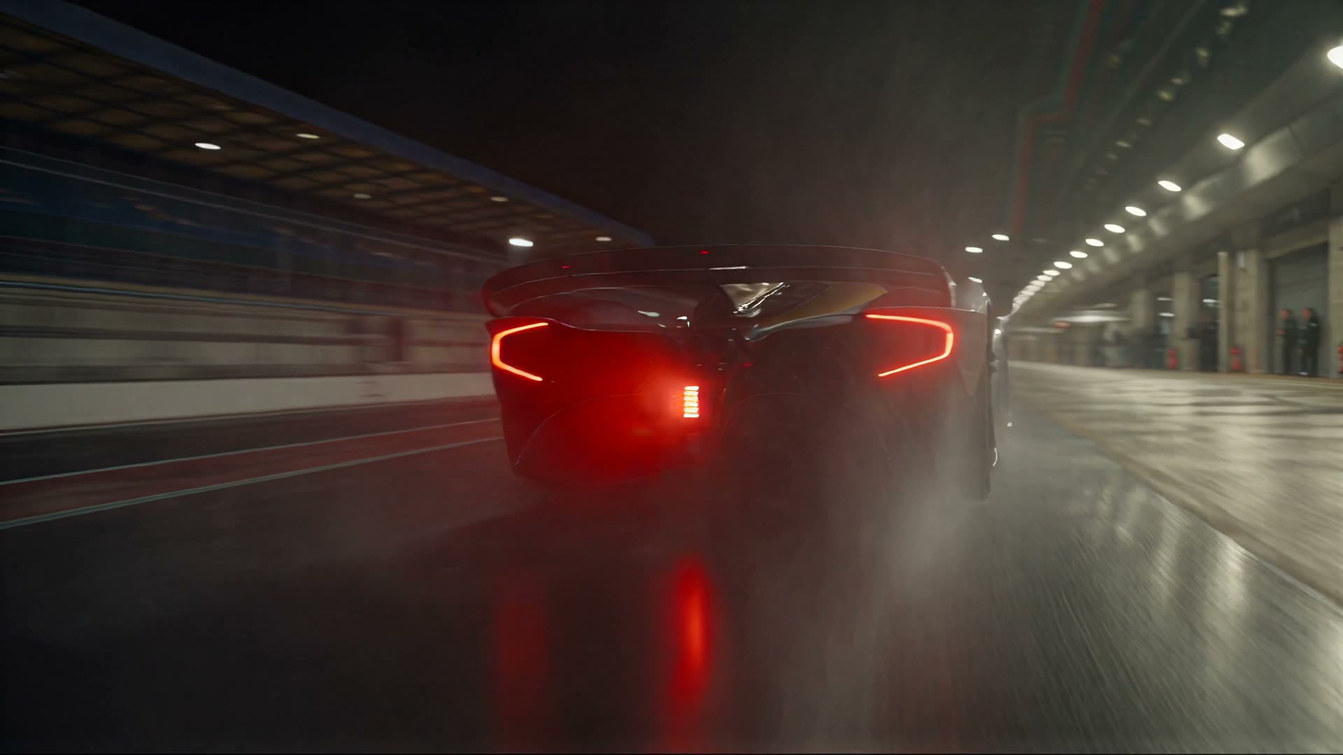 Competition car moving down the floodlit pit lane at night.