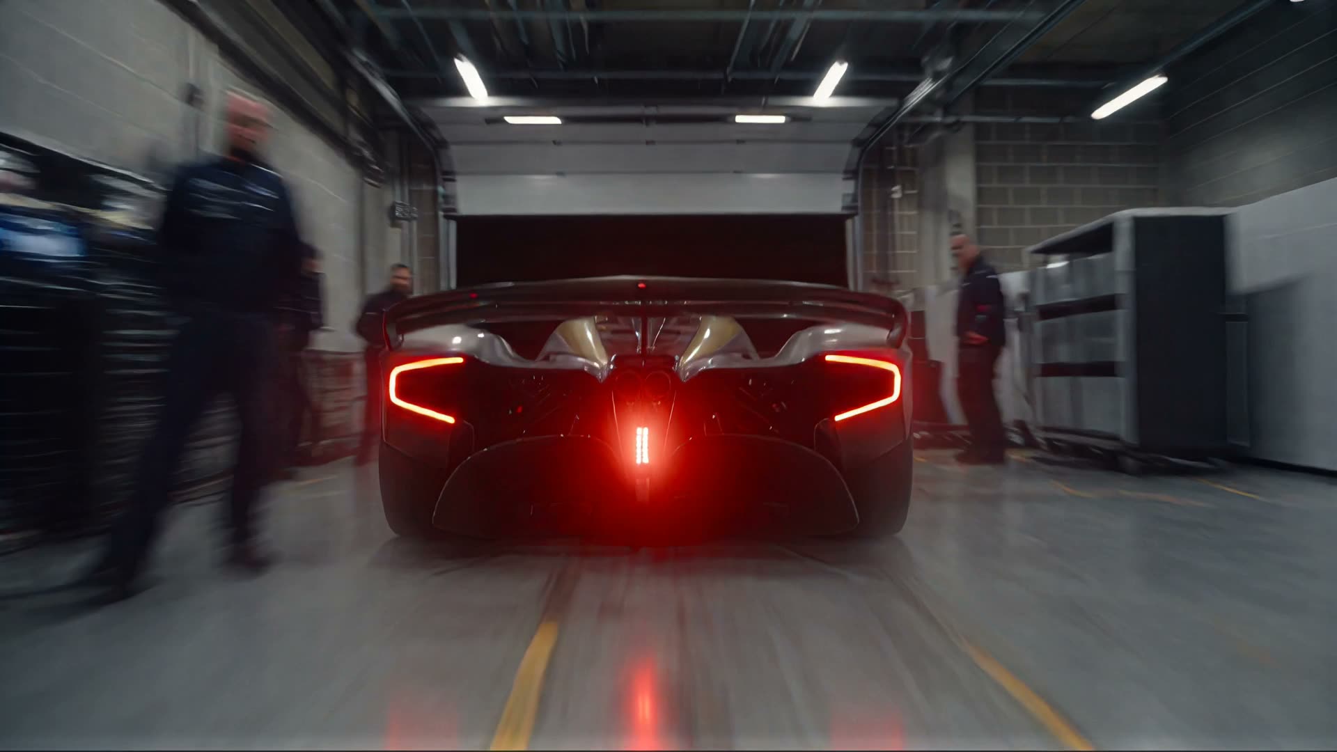 La vettura rientra nel box sotto le luci al neon.